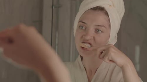 Woman Brushing Teeth in Bathroom