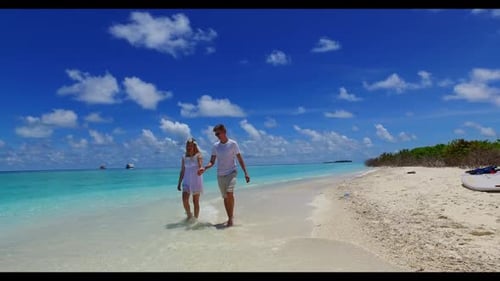 Man and lady engaged on relaxing resort beach voyage by blue ocean with white sand background of the