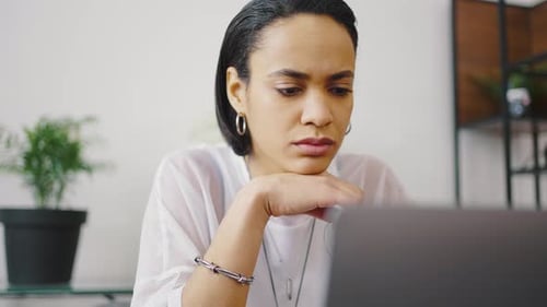Nahaufnahme Porträt eines Mädchens gemischter Abstammung, die im Coworking Space oder remote von zu Hause aus arbeitet