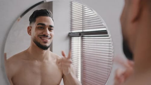 Nahaufnahme Männliche Reflexion im Spiegel Lächeln Selbstbewusst 30er Jahre unrasierter Kerl Machen Hey You Geste Pounting