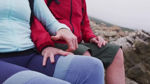 Affectionate Couple Holding Hands on Rocky Beach