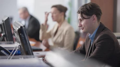 Side View Portrait of Focused Handsome Caucasian Man Working Online in Office