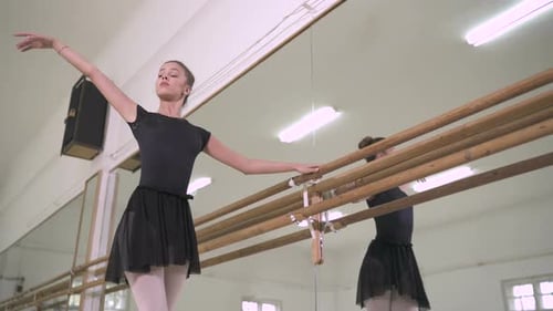 Young Woman Ballet Dancer Practicing at Barre