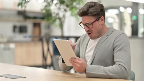Man Using Tablet Device in Workplace Setting