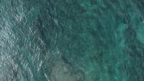 Luftaufnahme von oben auf das türkisgrüne Wasser des Pazifischen Ozeans, wodurch eine wunderschöne Textur entsteht