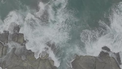 Waves Crash Against Rocks in the Ocean