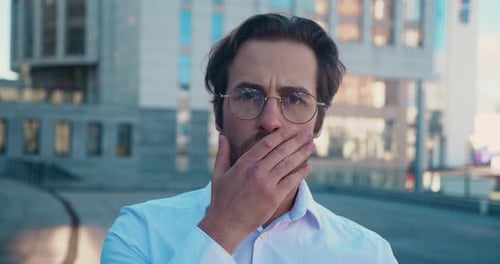 Surprised Man with Glasses Reacts in Urban Setting