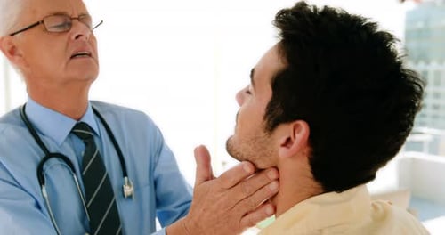 Doctor Examining Young Adult Patient in Bright Office