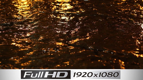 Water Flowing Down Urban Street Reflecting City Lights