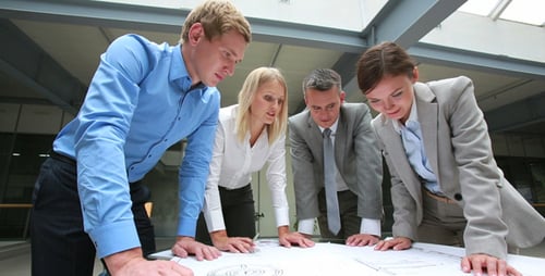 Team of Architects Reviewing Blueprint Together