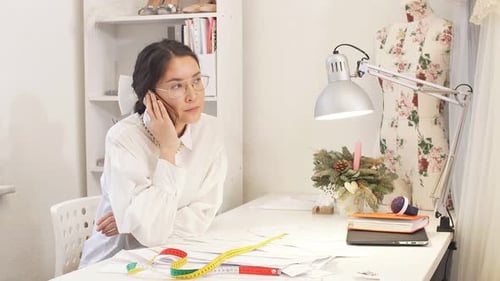 Dressmaker Talking on Mobile Phone in Studio