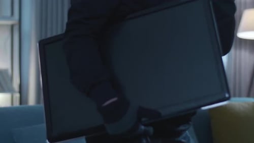 Close Up Of A Thief Man Holding Flashlight Stealing A Television In Someone's House
