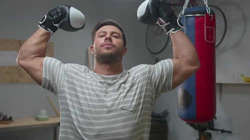 Man Stretches Arms While Wearing Boxing Gloves