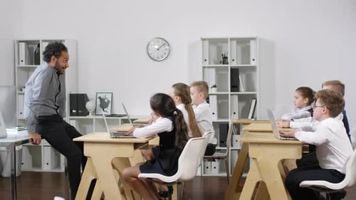 Un enseignant afro-américain charismatique donne une leçon aux élèves du primaire