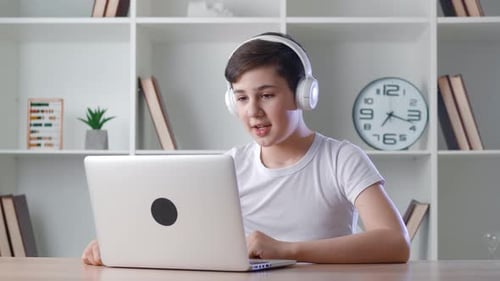 Teen Boy Video Chatting on Laptop Indoors