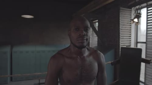 Confident Black Boxer with Bare Chest Posing at Fight Club