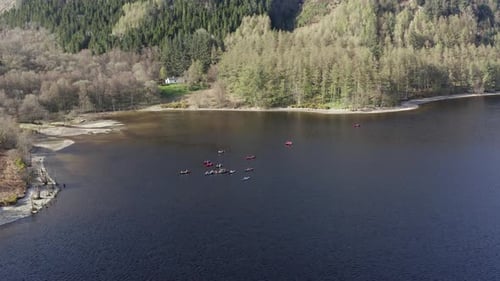 Canoeists on a Lake Surrounded by Forests and Mountains