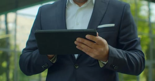 Close Up of Man Holding Modern Digital Tablet. Businessman Typing on His Digital Tablet. Businessman