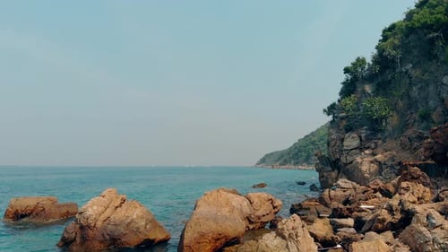 Brown Rocks on Beach Azure Ocean Coast Covered with Jungle