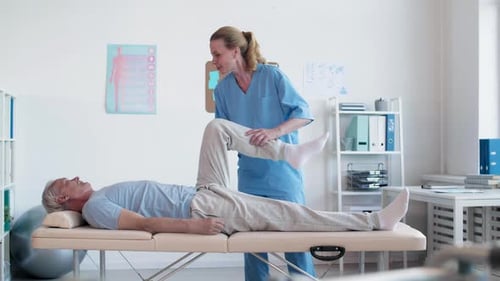 Therapist Assisting Senior Patient with Leg Exercise