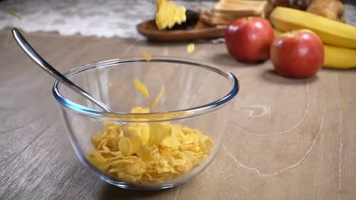 Corn Flakes Falling into Glass Bowl for Breakfast