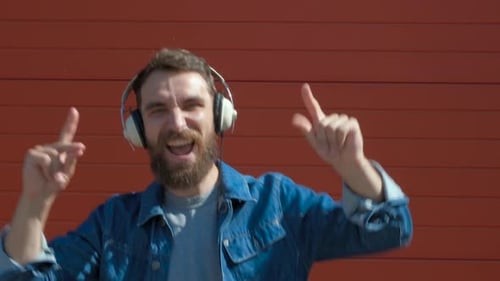 Young Man Dancing to Music With Headphones Outdoors