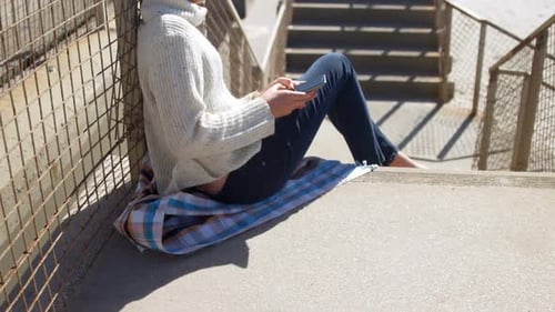 Girl using mobile phone near beach