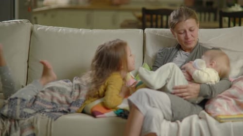 Mother and Children Relaxing on Couch Together