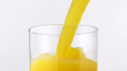 Bright Yellow Juice Poured into a Glass