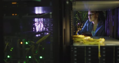 Young Woman Works in Dark Server Room