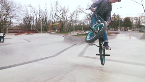 BMX Rider Doing Tricks in Cocncrete Skatepark
