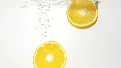 Orange Slices Falling into Clear Water