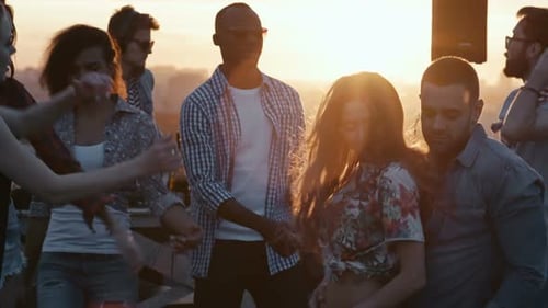 Friends Dancing at Rooftop Party During Sunset