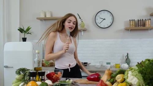 Young Woman Dancing and Singing in Kitchen