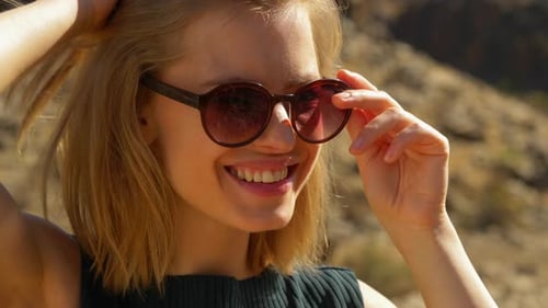 Blonde Model Laughing Putting Sunglasses on Top of Her Head
