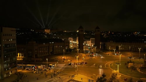 Praça Espanhola (Placa d'Espanya) à noite. Ônibus e carros andando. MNAC em segundo plano. Barcelona, Spa