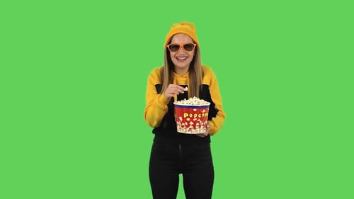Modern Girl in Yellow Hat in 3D Glasses Is Watching a Funny Movie and Eating Popcorn and Laughing