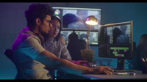 Video Editors Collaborating in Modern Office at Night