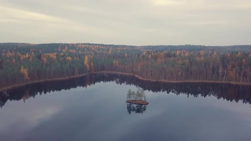 small island in calm lake aerial footage