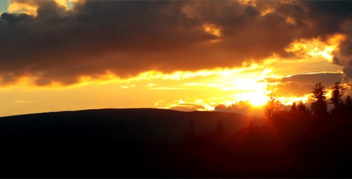 Golden Sunset over Mountainous Forest Landscape