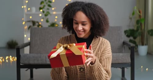 Young Woman Presents a Gift with a Smile