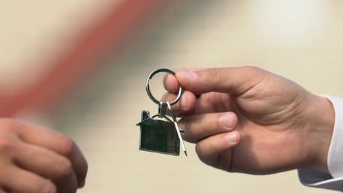 Mano masculina que toma la llave de la casa del agente inmobiliario