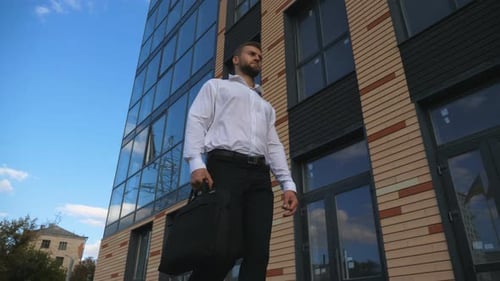 Successful Businessman with Briefcase Walking at Urban Street