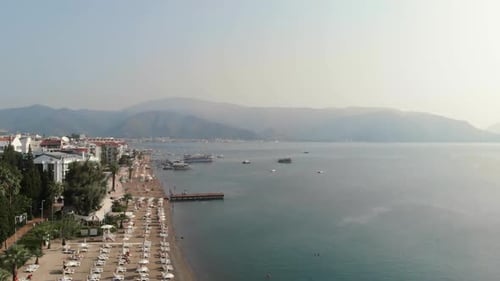The Camera Flies Along the Coast of the City Beach in the Mediterranean Sea. Aerial View. Beach with