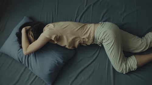 Woman Lying Down on Bed in Home Bedroom