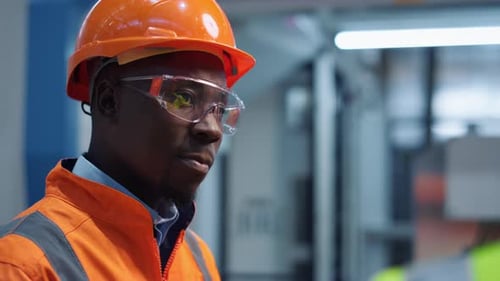 Man Engineer schüttelt den Kopf und trägt Sicherheitsuniform bei moderner Fabrik-Nahaufnahme
