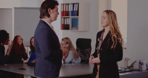 Colleagues Discussing and Handshaking in Office