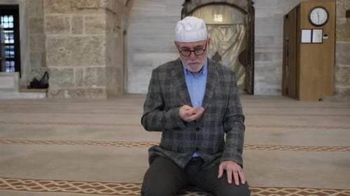 Mature Man Kneeling in Prayer Indoors