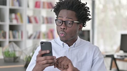 Young Adult Celebrating While Using Cell Phone