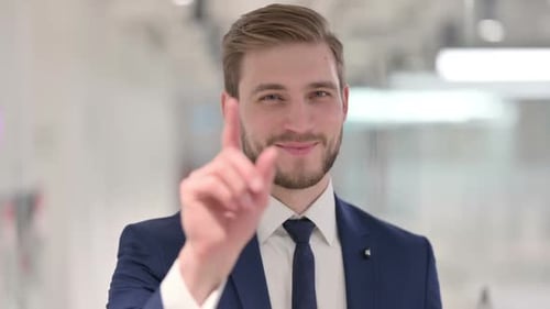 Young Businessman Pointing at Camera Inviting